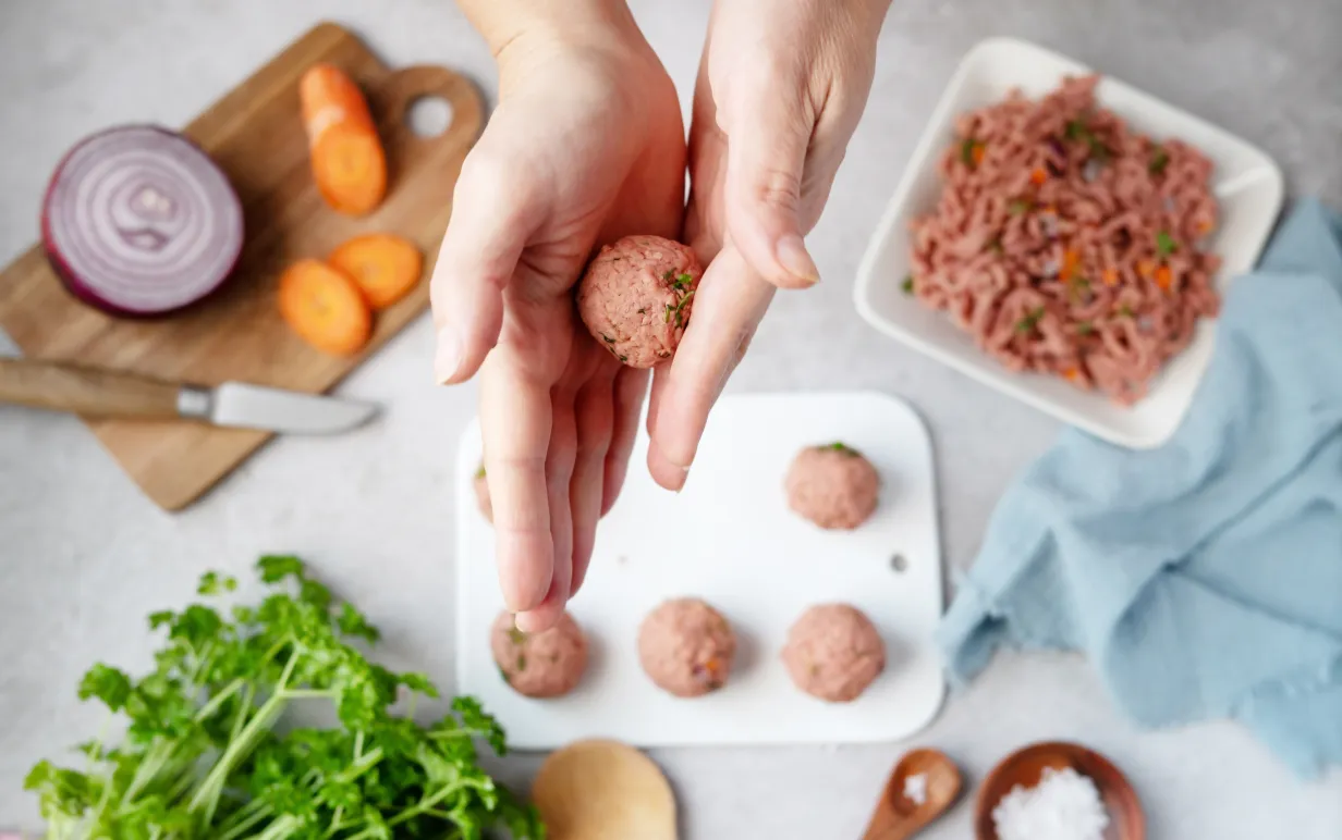 Kvinna som rullar växtbaserade köttbullar