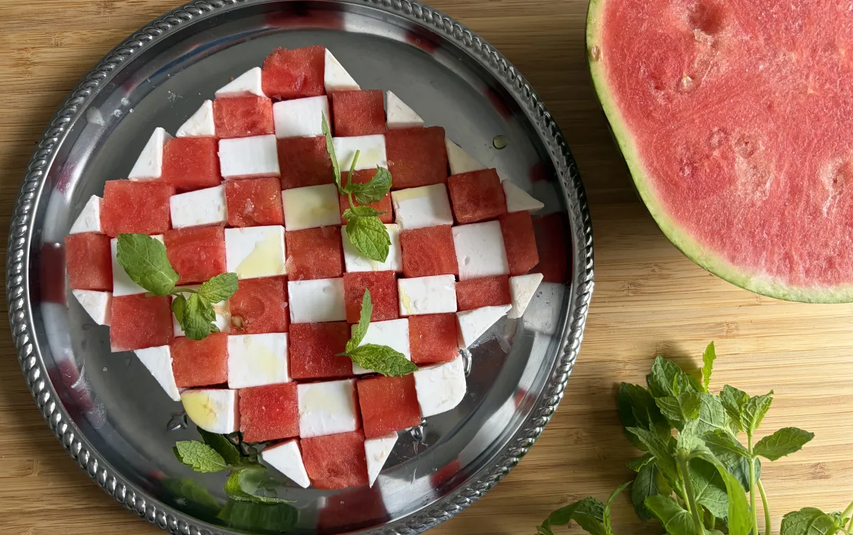 Plockbricka med fetaost och melon i ett schackmönster