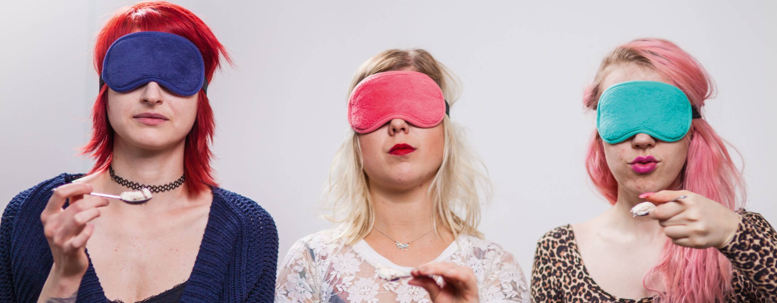 Tre personer sitter med ögonbindel och varsin sked glass.