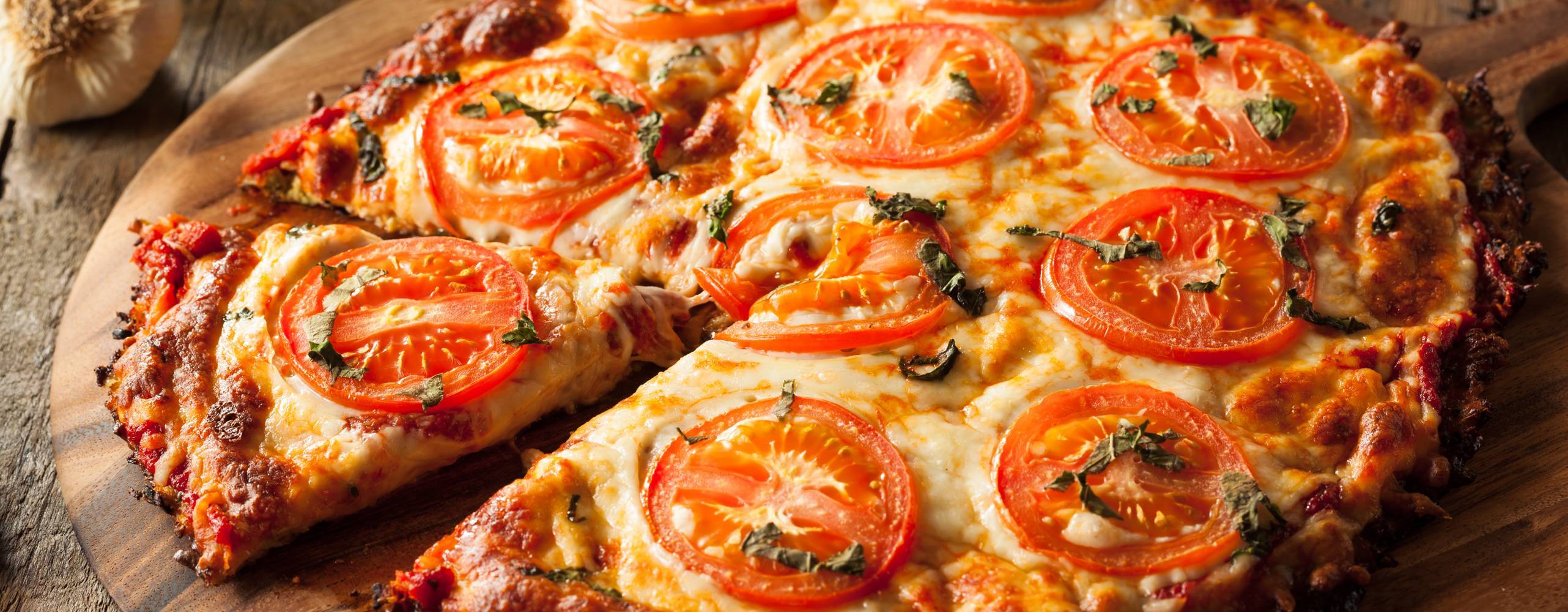 Vegansk pizza på rund träbräda