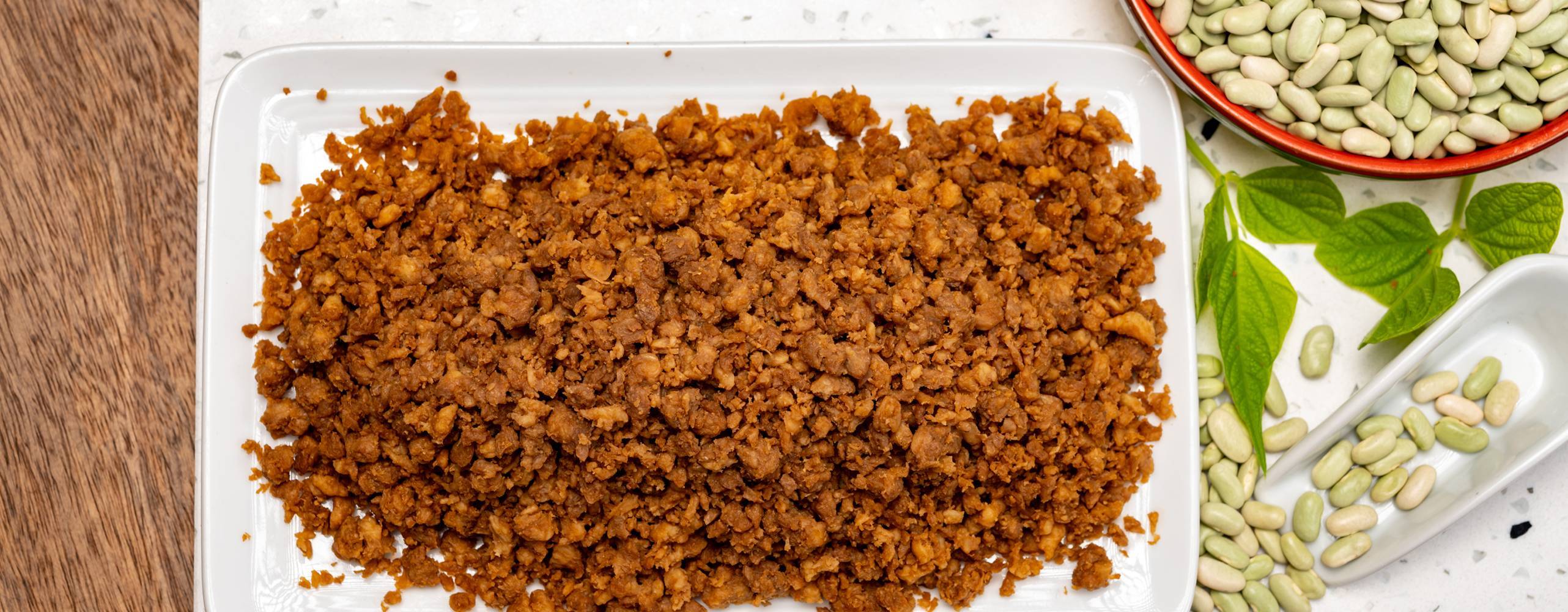 vegansk färs på en tallrik intill okokta bönor