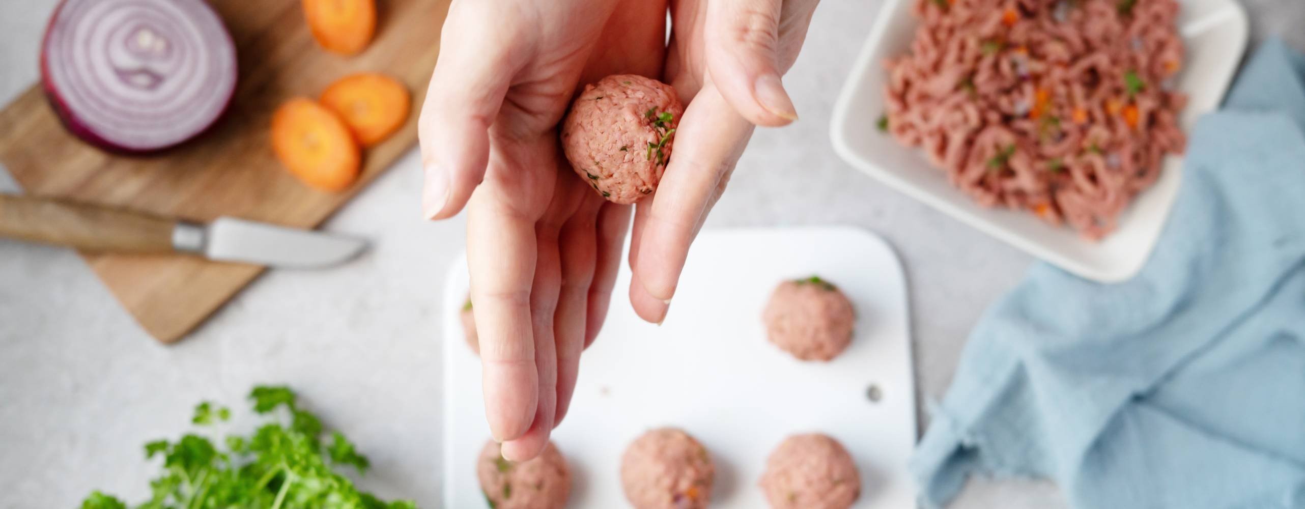 Kvinna som rullar växtbaserade köttbullar