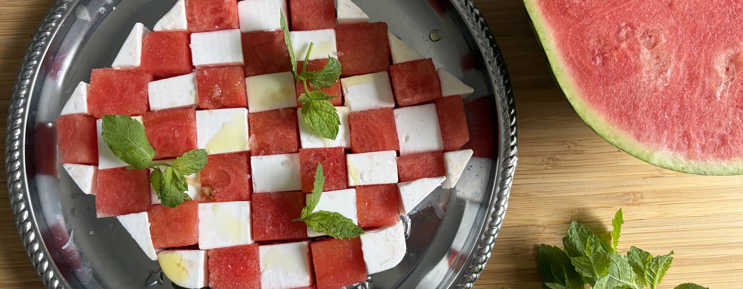 Plockbricka med fetaost och melon i ett schackmönster