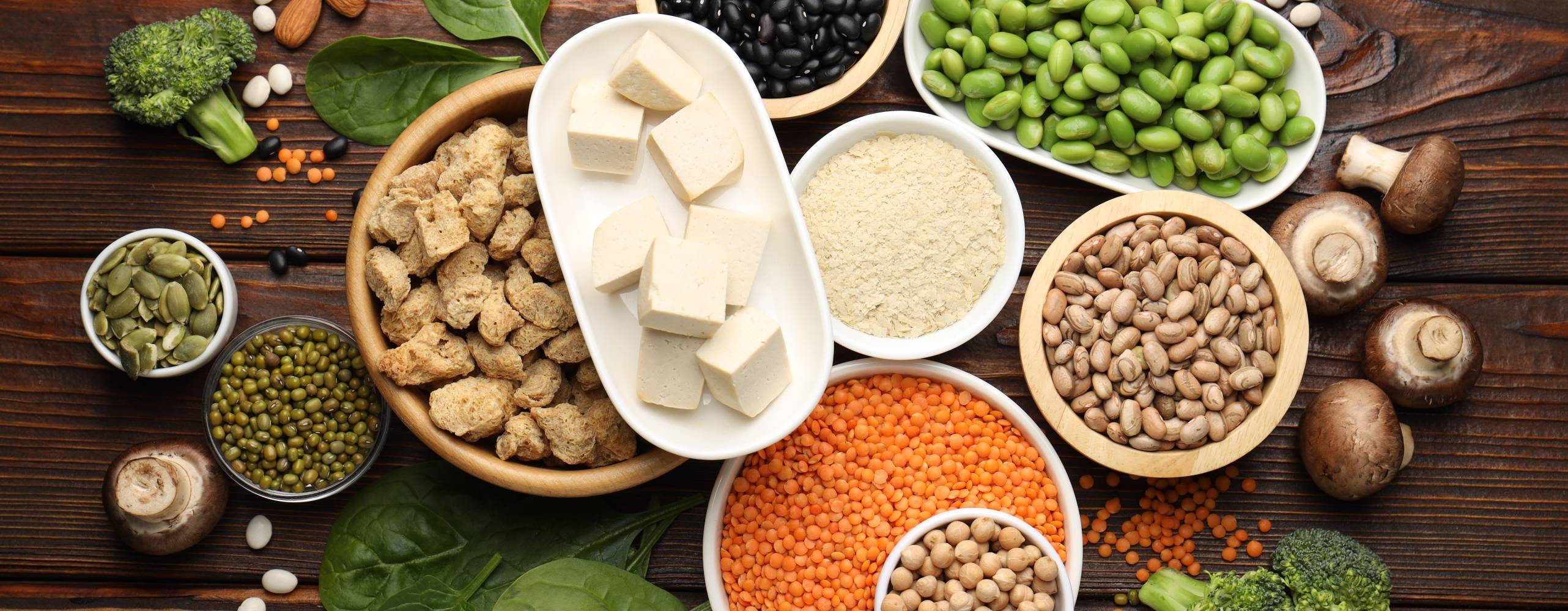 Olika veganska produkter på träbord, platt låg. Proteinkälla