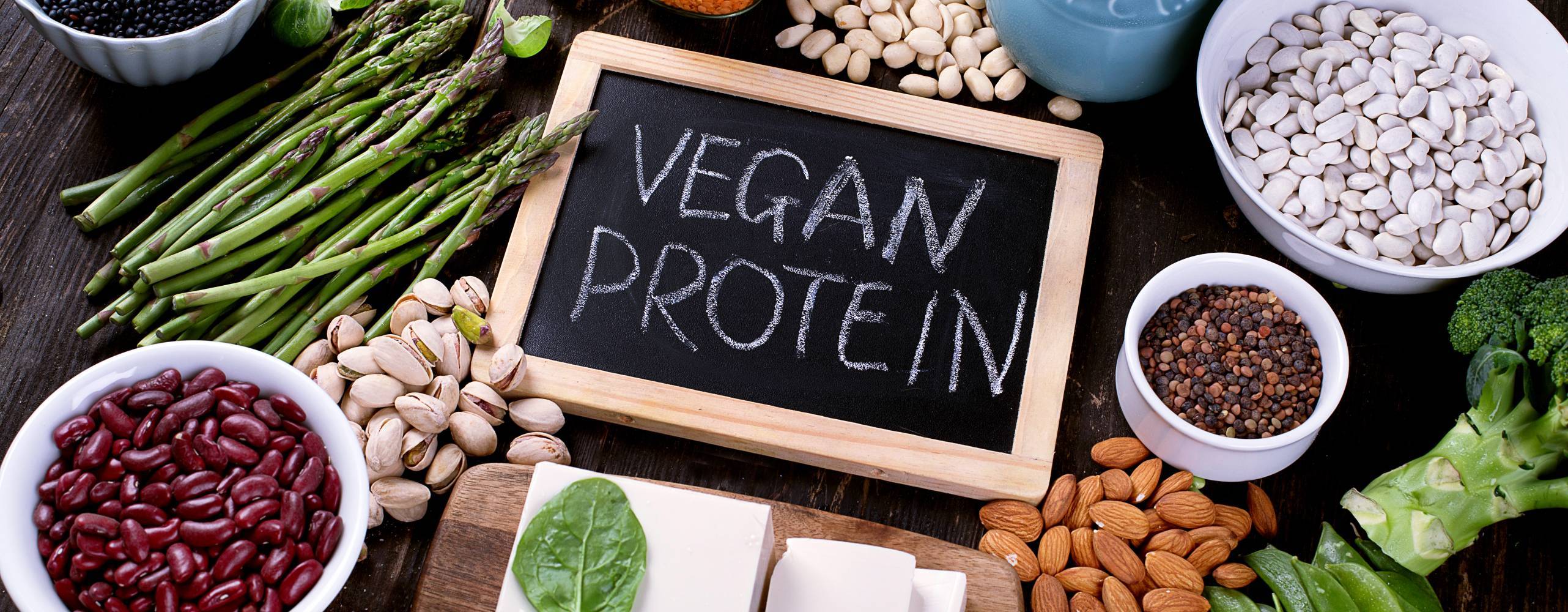 Bild på svart skrivtavla med texten vegan protein, omringad av diverse grönsaker